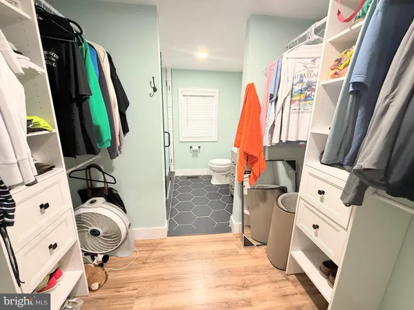 a view of walk in closet with clothes and shoes