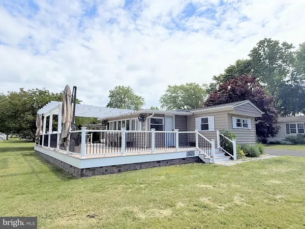 a view of a house with wooden deck and a big yard
