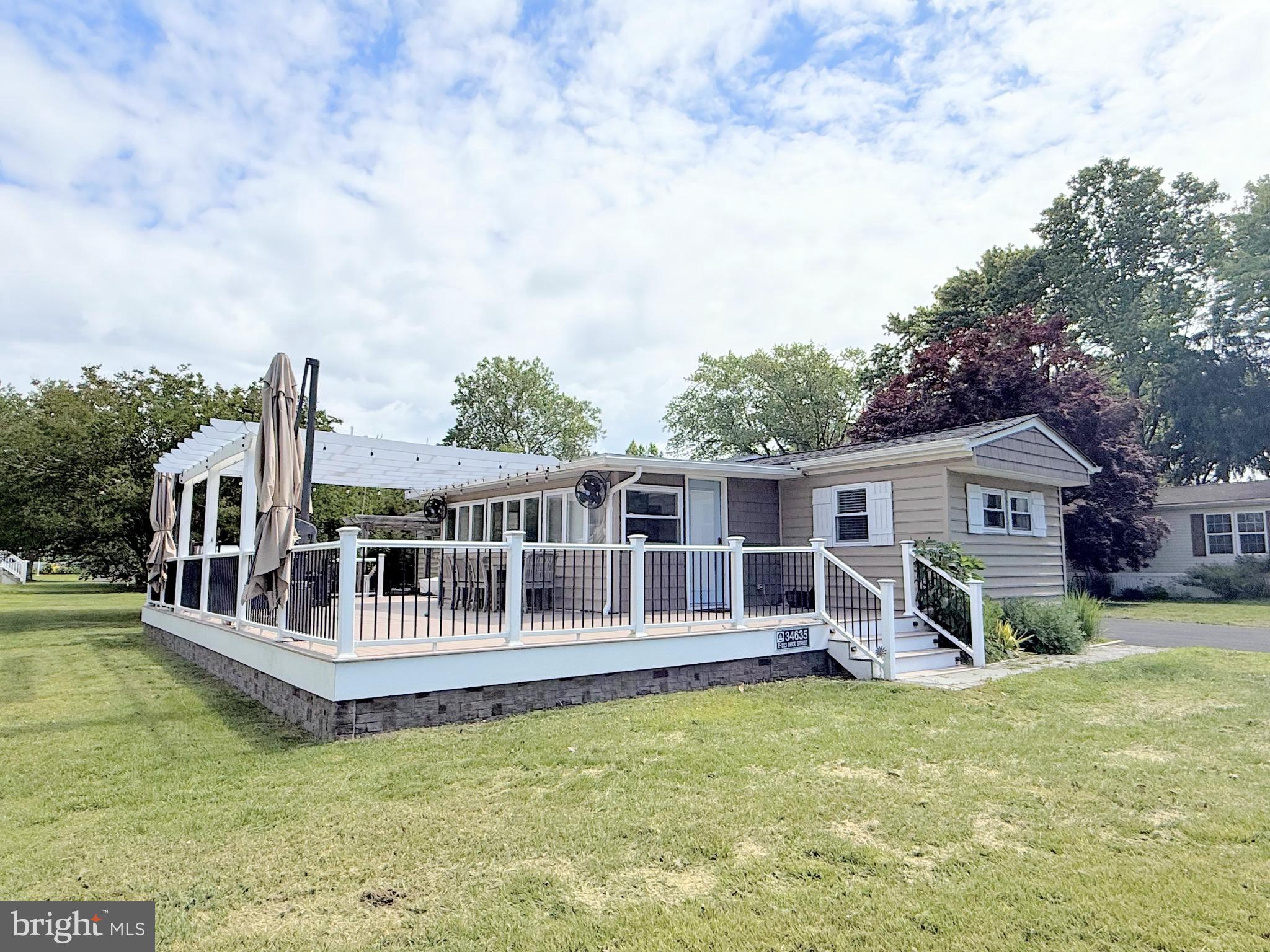 34635 Deck Street, Unit E323 Long Neck, DE 19966 - Photo 5 of 44 a view of a house with wooden deck and a big yard