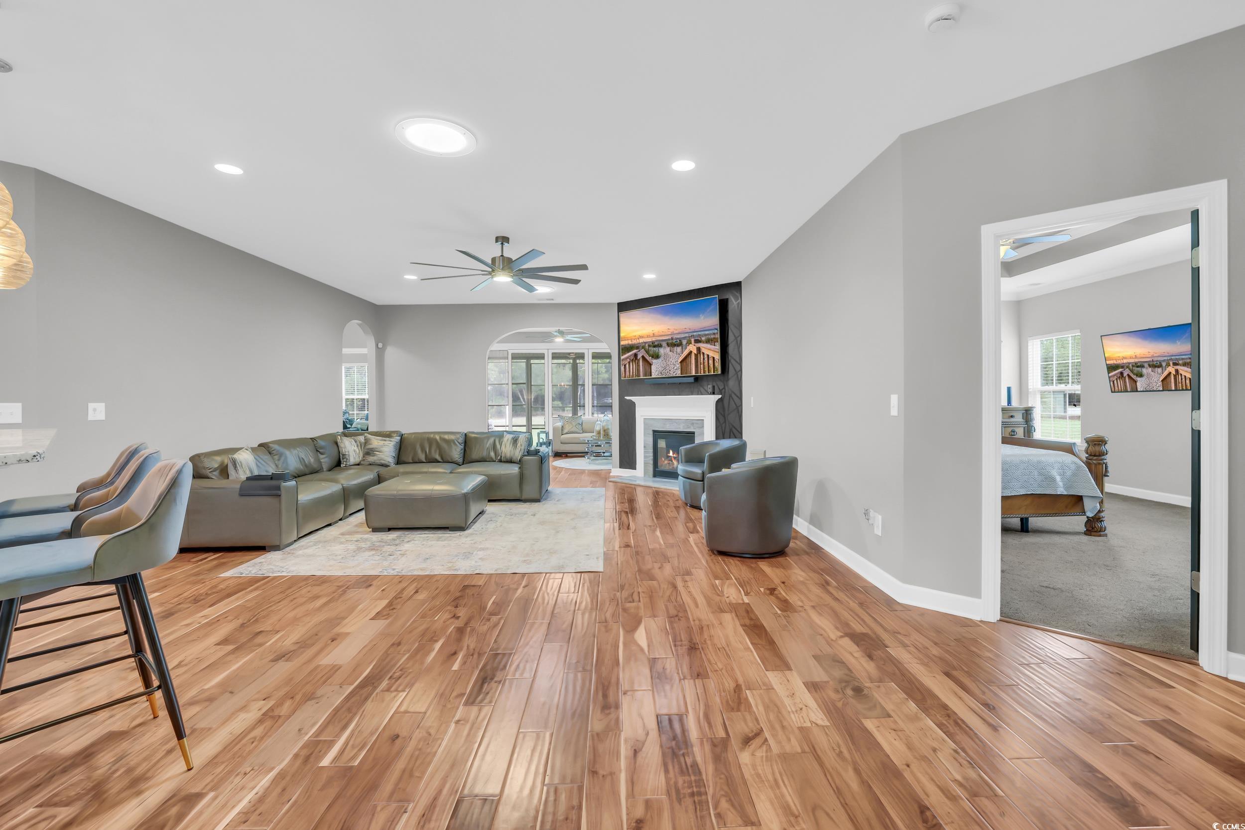1705 Brookshade Court Conway, SC 29526 - Photo 12 of 40 Living area with recessed lighting, a ceiling fan, a glass covered fireplace, light wood-type flooring, and arched walkways