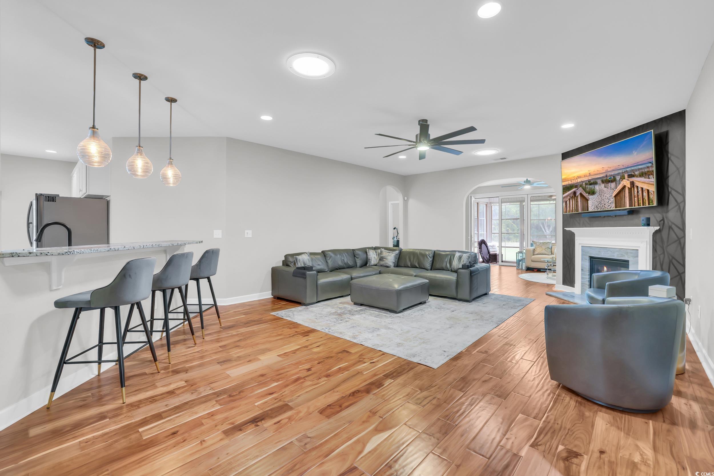 1705 Brookshade Court Conway, SC 29526 - Photo 13 of 40 Living area with arched walkways, recessed lighting, ceiling fan, light wood-style floors, and a glass covered fireplace