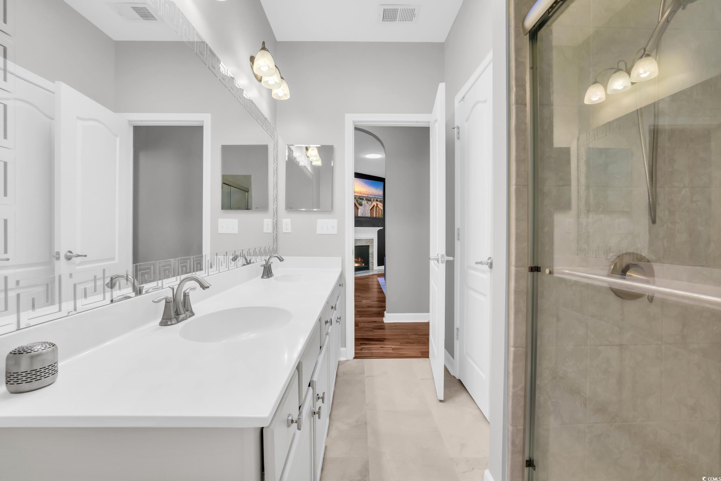 1705 Brookshade Court Conway, SC 29526 - Photo 26 of 40 Bathroom featuring double vanity, a shower stall, and a warm lit fireplace