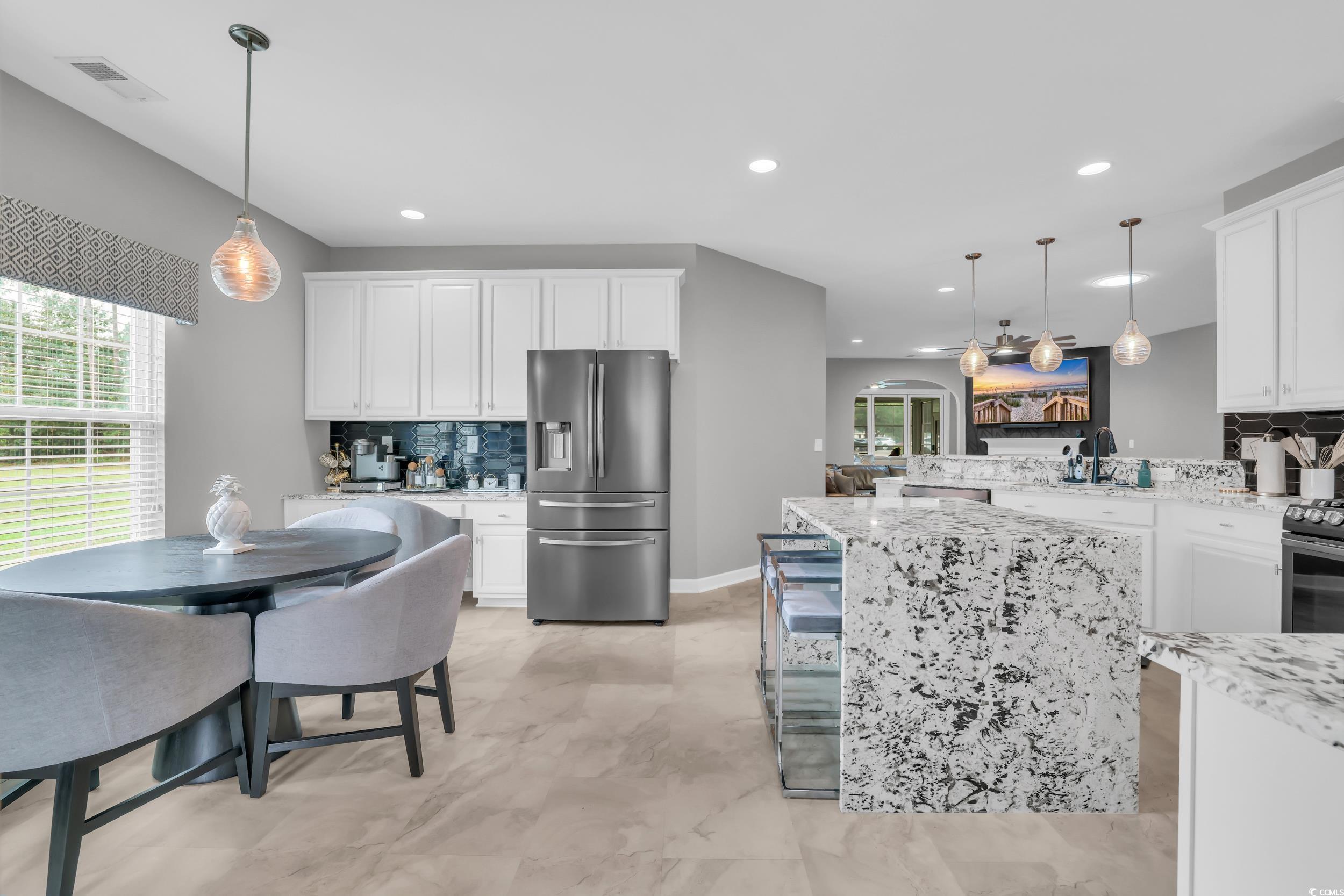 1705 Brookshade Court Conway, SC 29526 - Photo 5 of 40 Kitchen featuring tasteful backsplash, hanging light fixtures, stainless steel appliances, white cabinets, and a peninsula