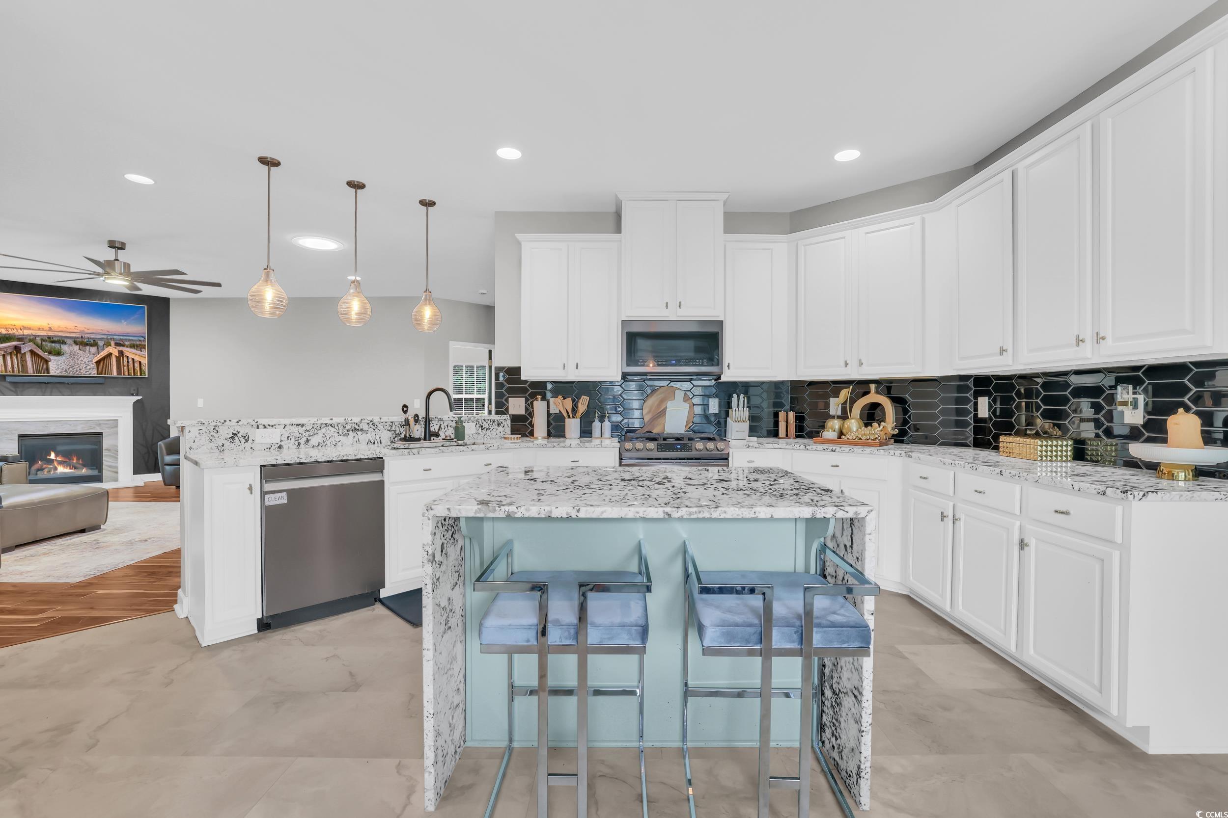 1705 Brookshade Court Conway, SC 29526 - Photo 8 of 40 Kitchen with light stone countertops, hanging light fixtures, white cabinetry, tasteful backsplash, and recessed lighting
