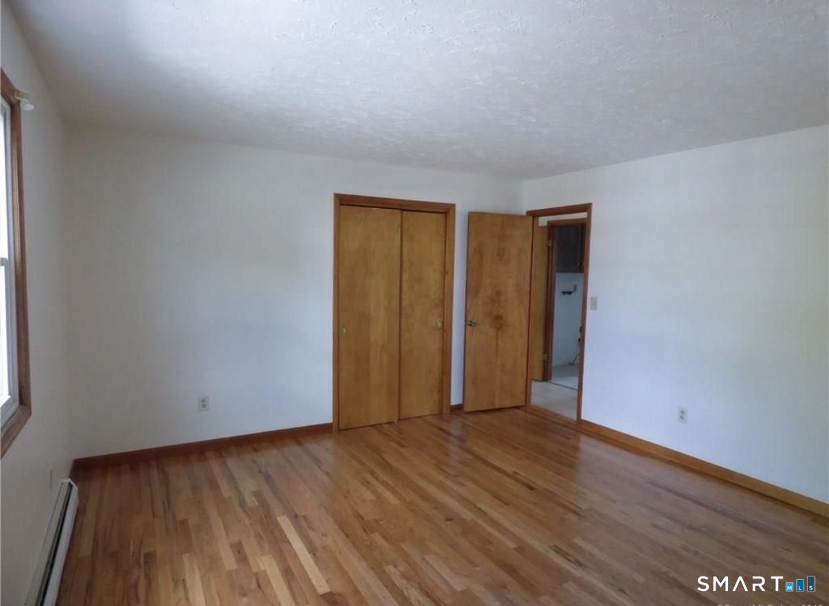 12 Hilltop Avenue, Unit 1 Waterbury, CT 06708 - Photo 5 of 7 a view of an empty room with wooden floor and a window