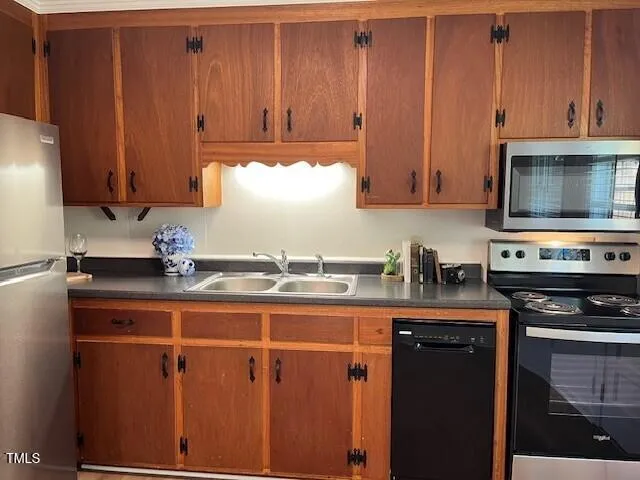 a kitchen with granite countertop a stove a sink and dishwasher wooden cabinets with granite countertops