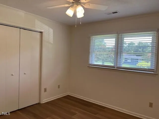 en empty room with wooden floor and windows