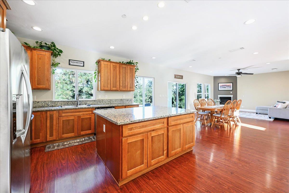 21895 One Fine Place Colfax, CA 95713 - Photo 20 of 82 a kitchen with stainless steel appliances granite countertop a table chairs and a wooden floor