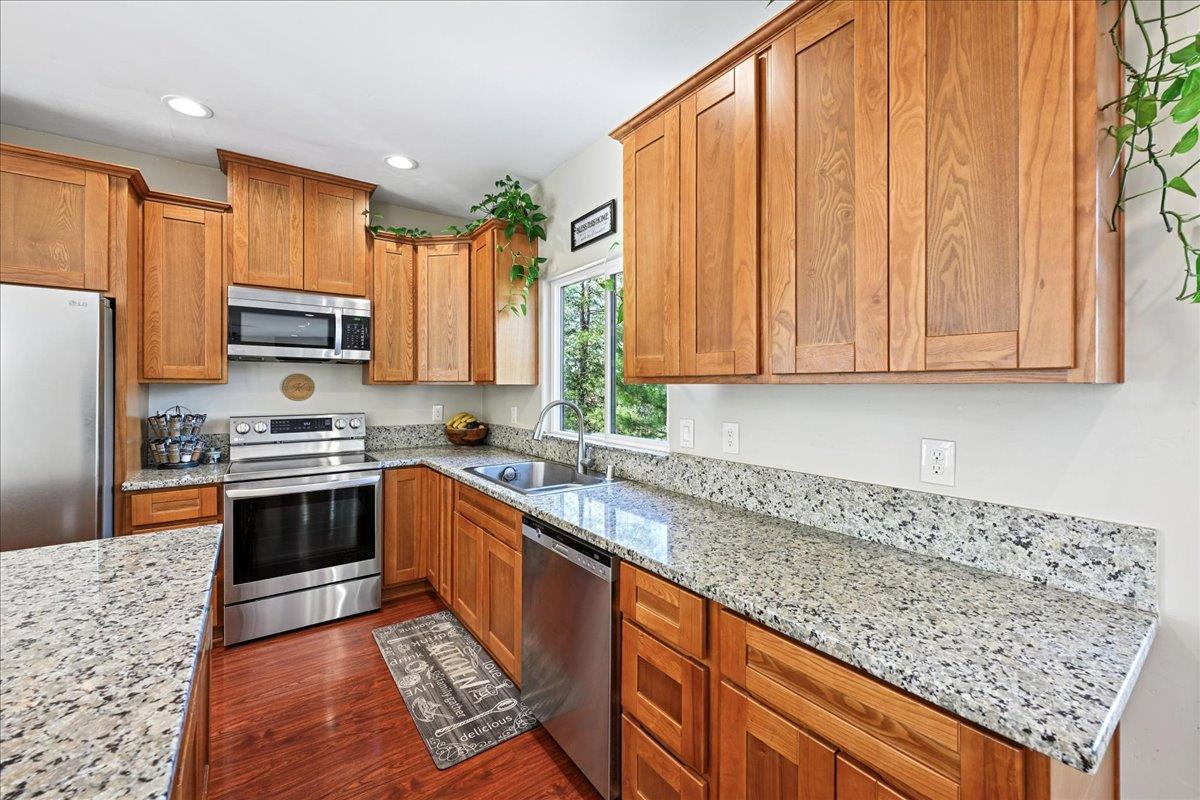 21895 One Fine Place Colfax, CA 95713 - Photo 21 of 81 a kitchen with stainless steel appliances granite countertop a stove a sink dishwasher and a refrigerator with wooden cabinets