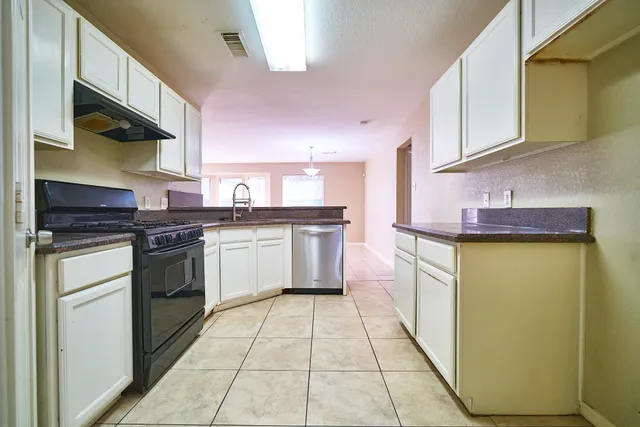 a kitchen with stainless steel appliances granite countertop a stove a sink and a microwave