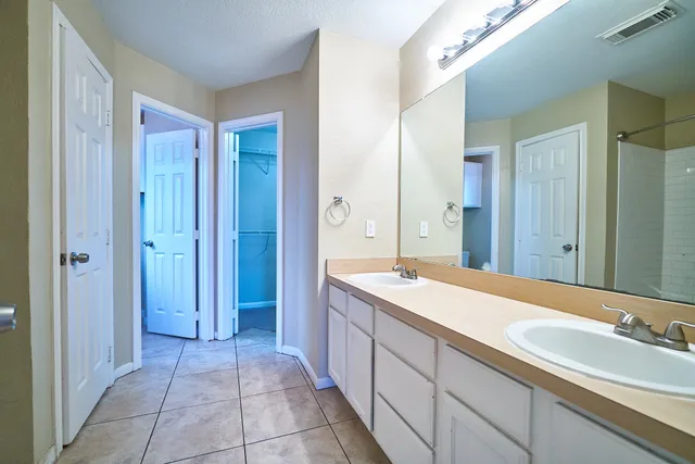 a spacious bathroom with a granite countertop sink and a mirror