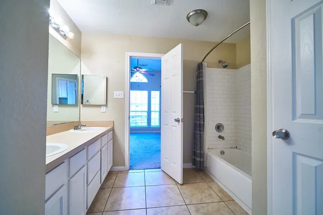 a bathroom with a tub sink shower and mirror
