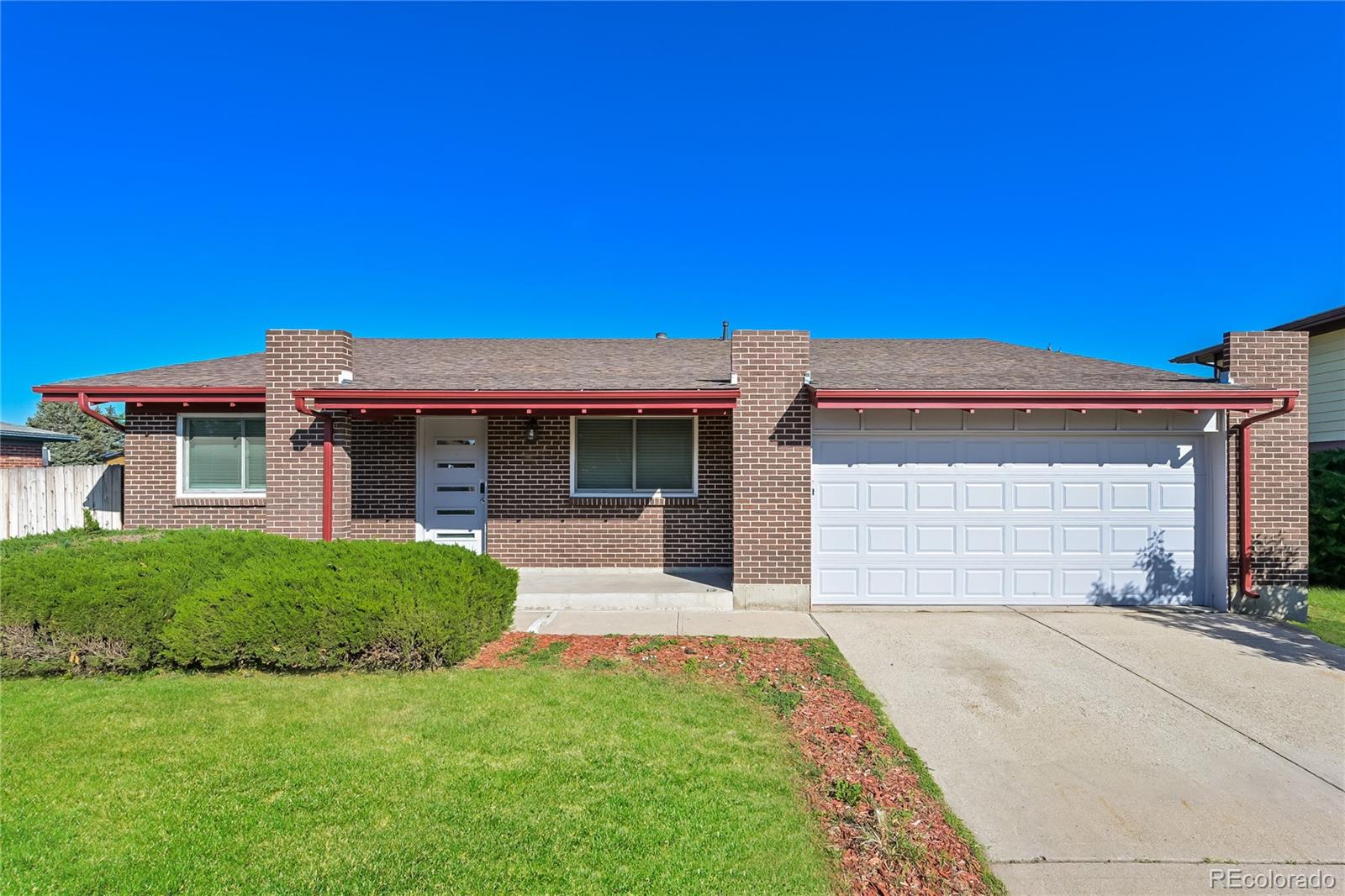 a front view of a house with a garden and yard
