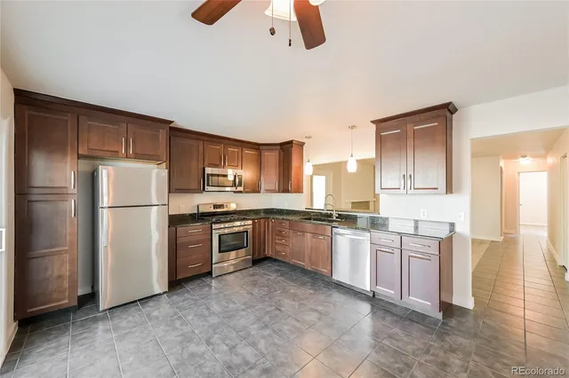 a large kitchen with a refrigerator a stove top oven a sink and dishwasher