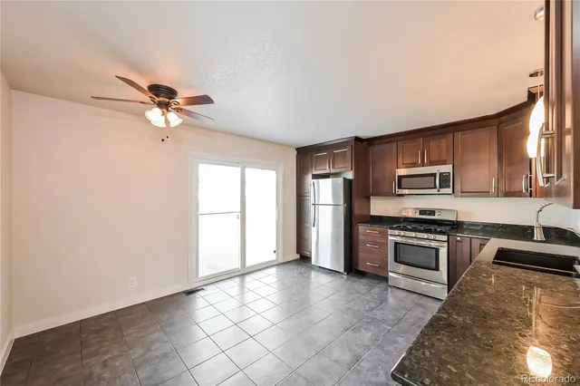 a kitchen with stainless steel appliances granite countertop a stove a sink and a refrigerator