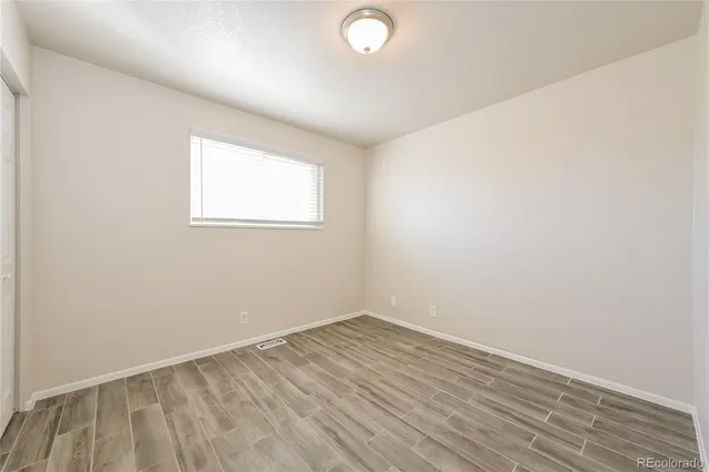 an empty room with closet and a ceiling fan