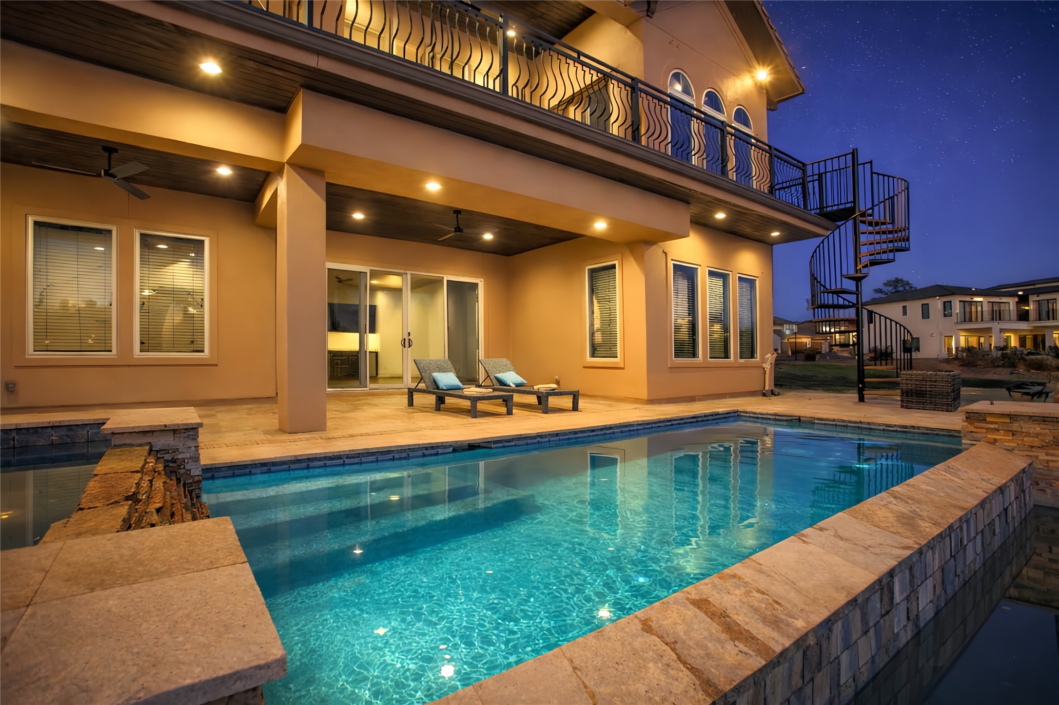 12349 Tramonto Conroe, TX 77304 - Photo 3 of 50 Backyard features a luxurious outdoor area with a sparkling pool, spacious patio, and elegant spiral staircase. Perfect for relaxing and entertaining.