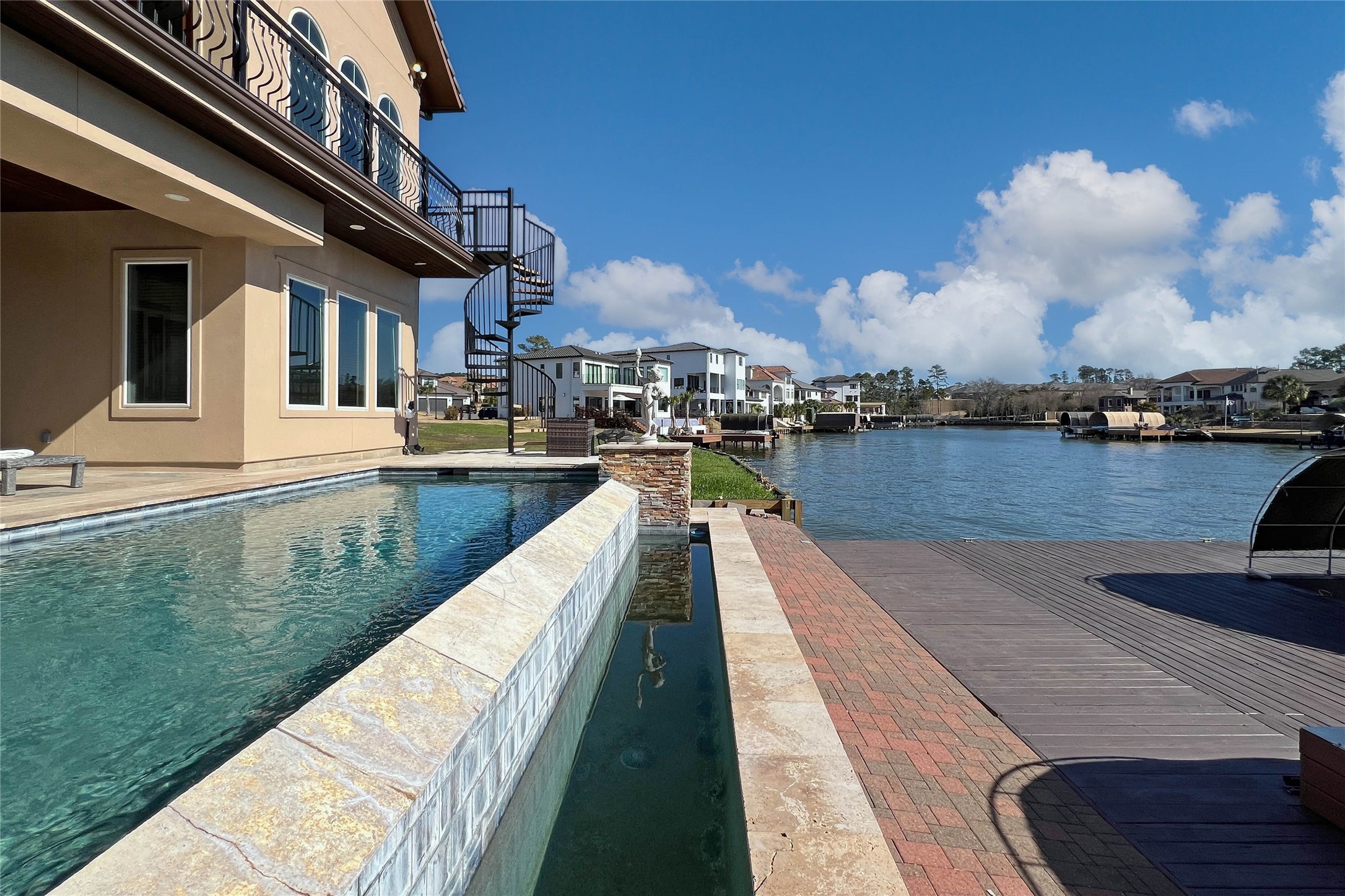 12349 Tramonto Conroe, TX 77304 - Photo 49 of 50 Modern waterfront home featuring a sleek pool, spacious deck, and scenic views of the waterway, perfect for luxurious living and entertaining.
