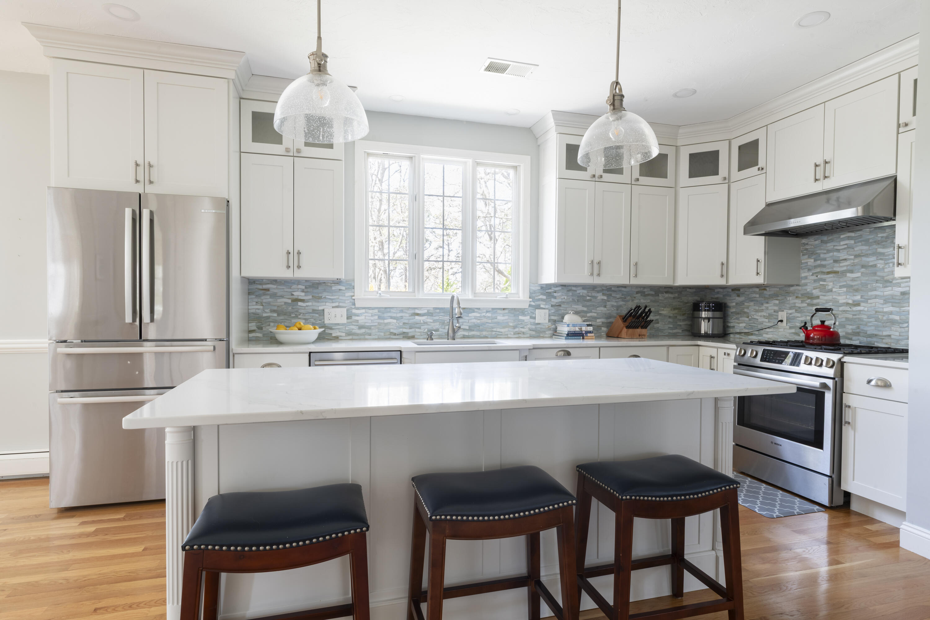 331 Riverview Drive Chatham, MA 02633 - Photo 14 of 50 a kitchen with stainless steel appliances a table chairs refrigerator and cabinets