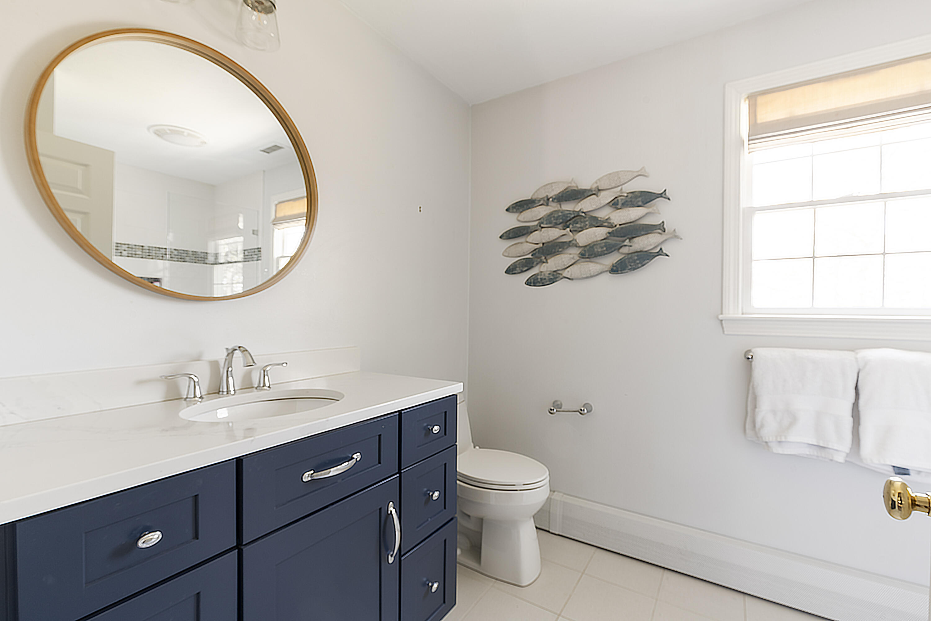 331 Riverview Drive Chatham, MA 02633 - Photo 36 of 50 a bathroom with a sink a mirror a toilet and a window