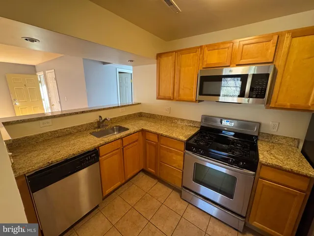 a kitchen with granite countertop a stove and a microwave
