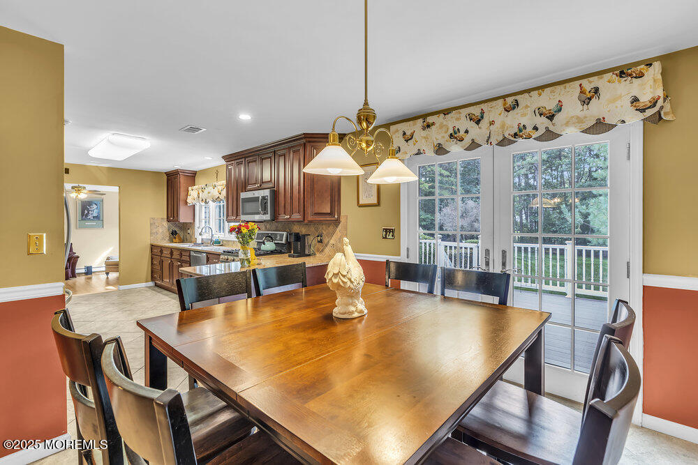 627 Reed Road Jackson, NJ 08527 - Photo 13 of 44 a dining room with furniture a chandelier and wooden floor