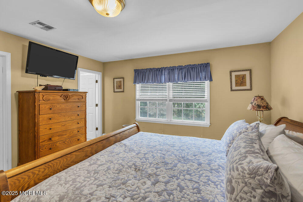627 Reed Road Jackson, NJ 08527 - Photo 25 of 44 a bedroom with a bed and flat screen tv