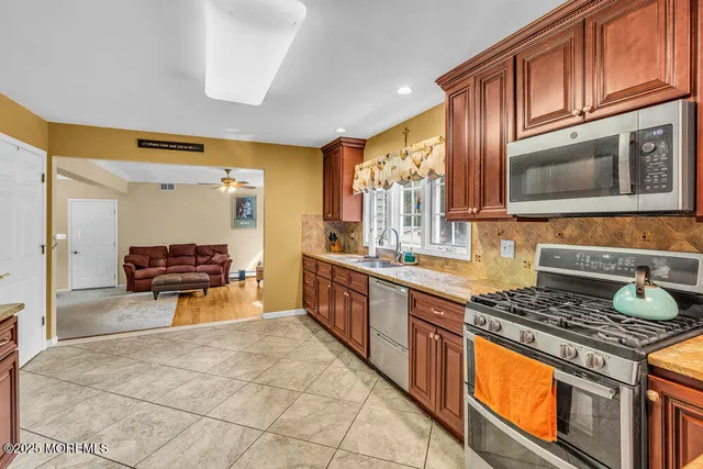 a kitchen with stainless steel appliances granite countertop a refrigerator stove and sink