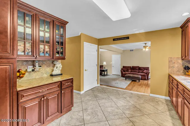 a kitchen with stainless steel appliances granite countertop wooden cabinets a stove a sink and a large window