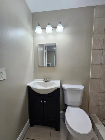 a bathroom with a toilet a sink and mirror