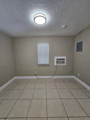 an empty room with windows and mirror