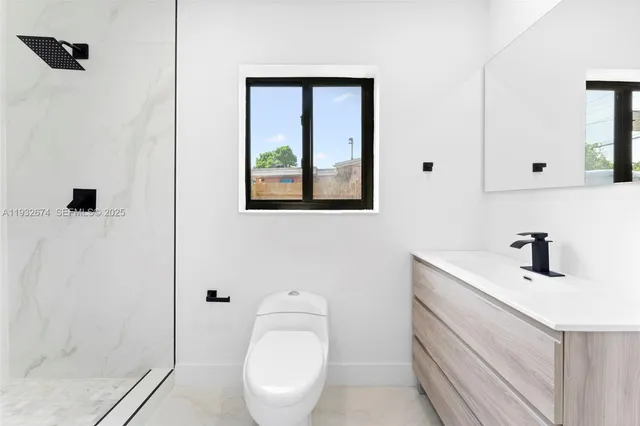 a bathroom with a toilet a sink a mirror and shower