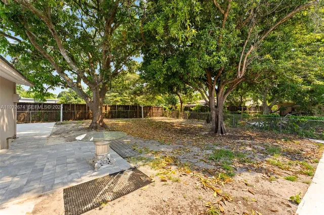 a view of a yard with plants and trees