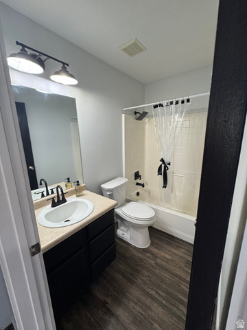 1237 South 260 West Payson, UT 84651 - Photo 48 of 81 Modern full bathroom featuring dual vanity with wood-finish countertop and round vessel sinks, matte black hardware and mirror fixtures, combined shower-tub with glass enclosure and neutral tile surround, wood-finish flooring throughout, and recessed ceil