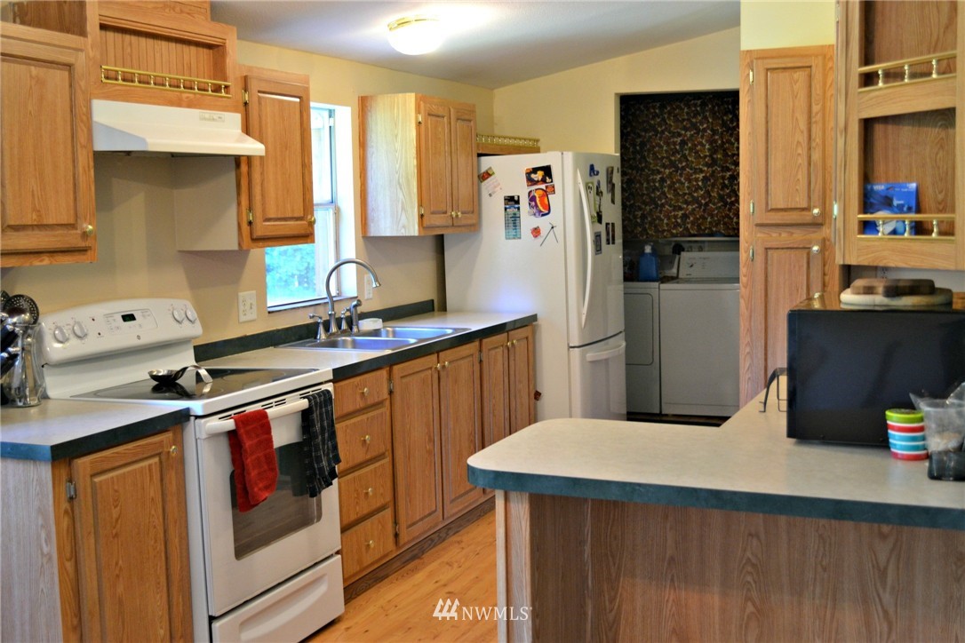 1462 North Fork Road Chehalis, WA 98532 - Photo 6 of 23 a kitchen with stainless steel appliances a sink a refrigerator and wooden cabinets