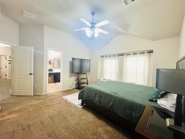 a bedroom with a bed window and a flat screen tv
