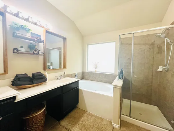 a bathroom with a double vanity sink a mirror and a bathtub