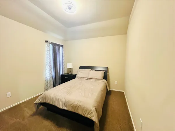 a bedroom with a bed and a night stand