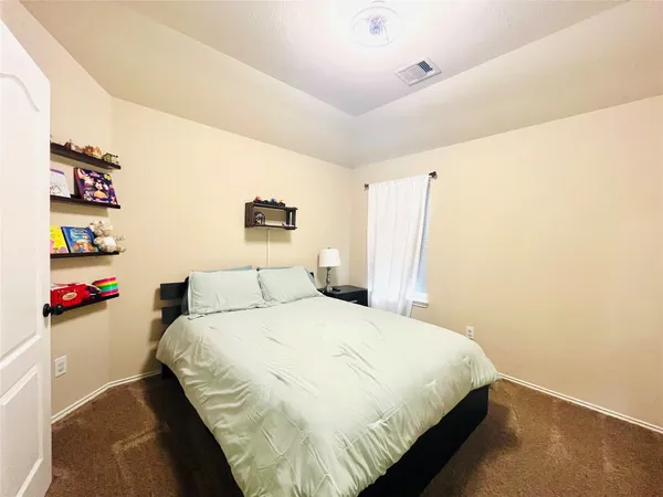 a bedroom with a bed and a painting on the wall