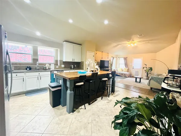 a kitchen with stainless steel appliances kitchen island granite countertop a stove a sink and a refrigerator