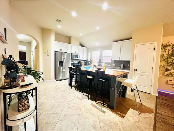 a kitchen with stainless steel appliances kitchen island granite countertop a refrigerator and a stove top oven