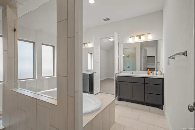 a bathroom with a tub sink and mirror
