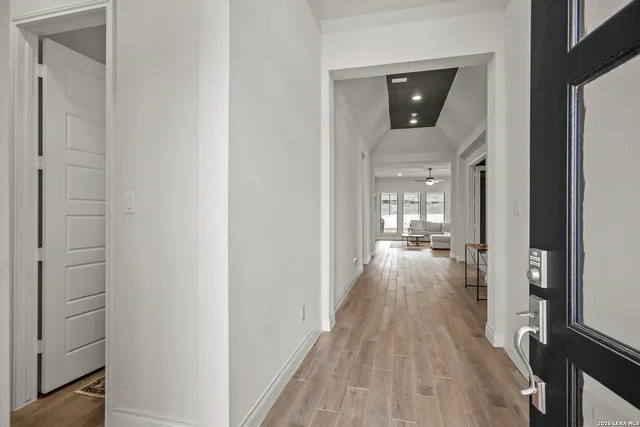 a view of a hallway with wooden floor windows and livingroom