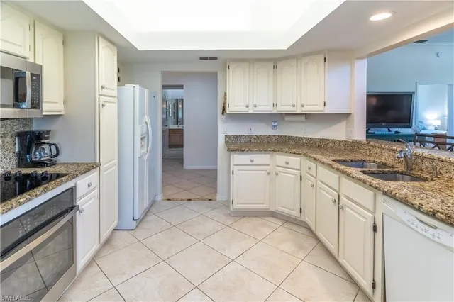 a kitchen with white cabinets sink and stainless steel appliances