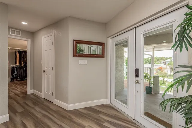 a view of a hallway with wooden floor and a living room