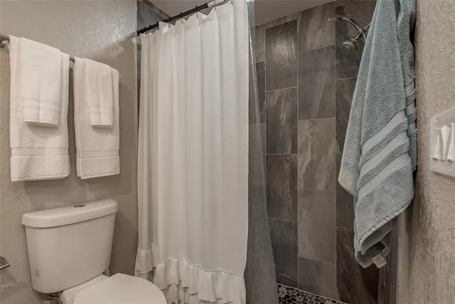 a bathroom with a toilet and shower
