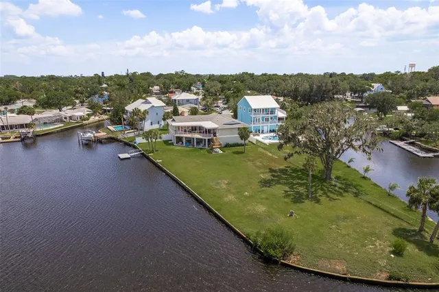 an aerial view of a house with a garden and lake view