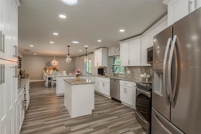 a kitchen with a sink stainless steel appliances cabinets and a counter top space