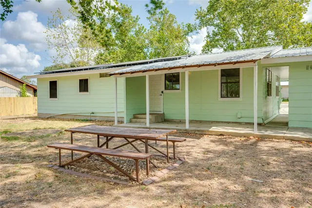 a backyard of a house with table and chairs