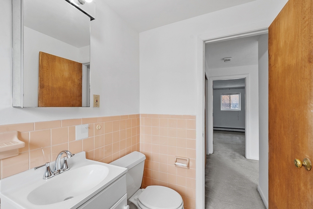 26 Bryon Road, Unit 3 Boston, MA 02467 - Photo 18 of 30 a bathroom with a toilet sink and mirror